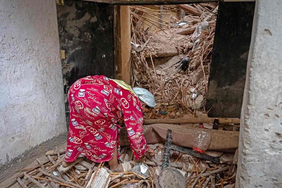 Emakume bat bere etxeko hondakinetan bilatzen, Marrakexen.