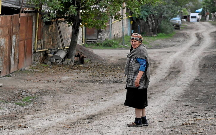 En la página anterior,  una mujer en la aldea armenia de Kordnizor. Junto a estas líneas, un puesto de observación armenio en la frontera y karabajíes escoltados en su huida a una base militar rusa