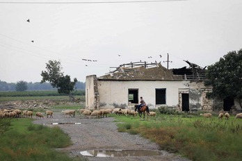 Un pastor a caballo lleva a su rebaño cerca de una casa destruida cerca del pueblo de Azad Qaraqoyunlu.