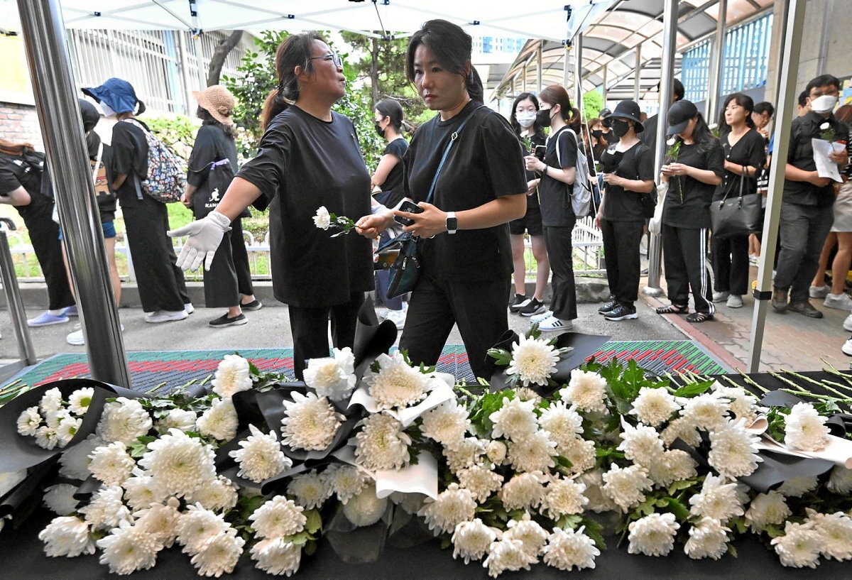 Herritarrak dolua erakusten duten loreak ipintzen, bere buruaz beste egin zuen 23 urteko Lee Min-so lehen mailako irakaskuntzako irakaslearen omenaldian. (Jung YEON-JE / AFP)