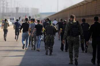 Milicianos de Hamas y jóvenes en la frontera de Gaza tras la incursión.