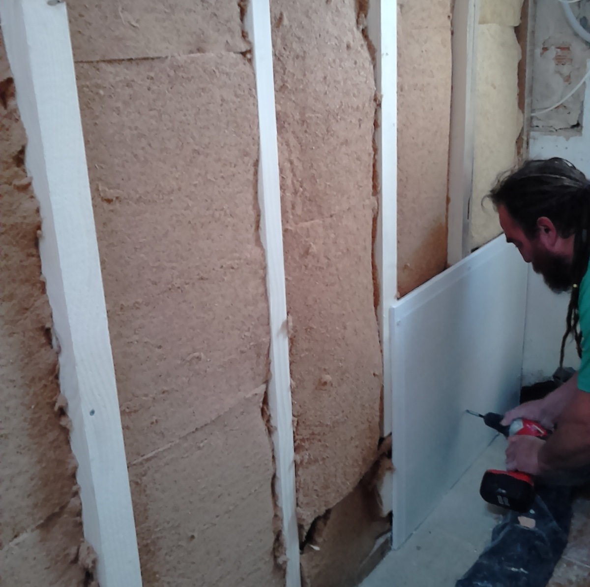 Trabajador aislar la pared de una habitación con aislamiento térmico de lana  de roca mineral