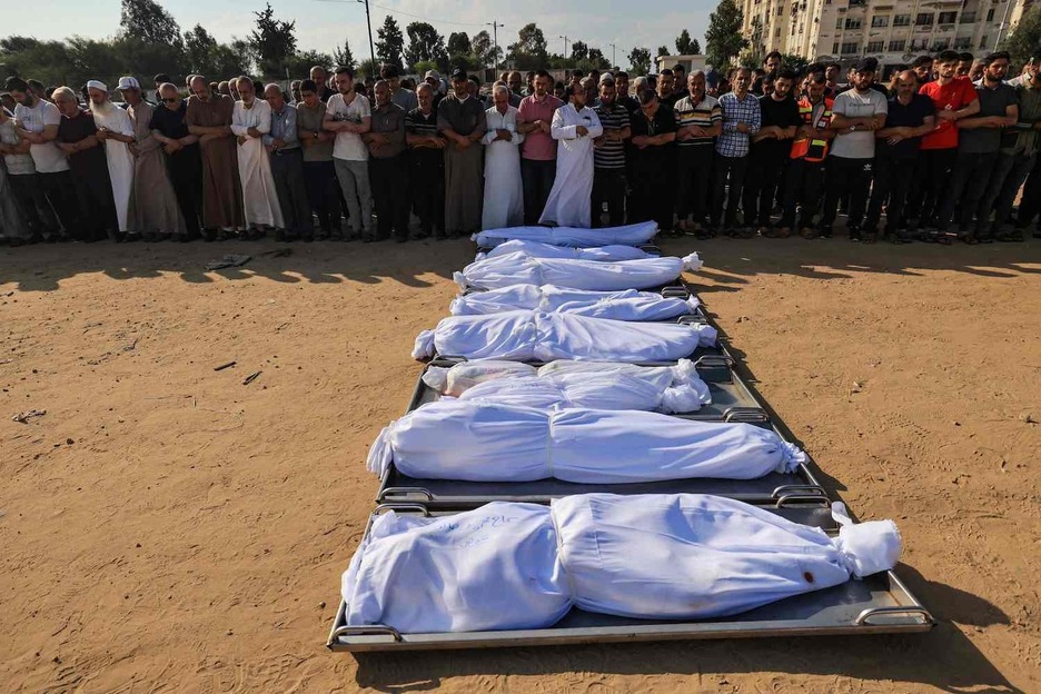 Palestinos rezan sobre los cuerpos de los miembros de la familia Agha muertos en un ataque israelí en Jan Yunis, en la Franja de Gaza. Palestinos rezan sobre los cuerpos de los miembros de la familia Agha muertos en un ataque israelí en Jan Yunis, en la Franja de Gaza.
