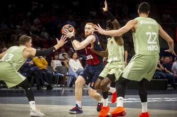 Nico Mannion, rodeado por dos defensores del Bayern, busca acabar la jugada.
