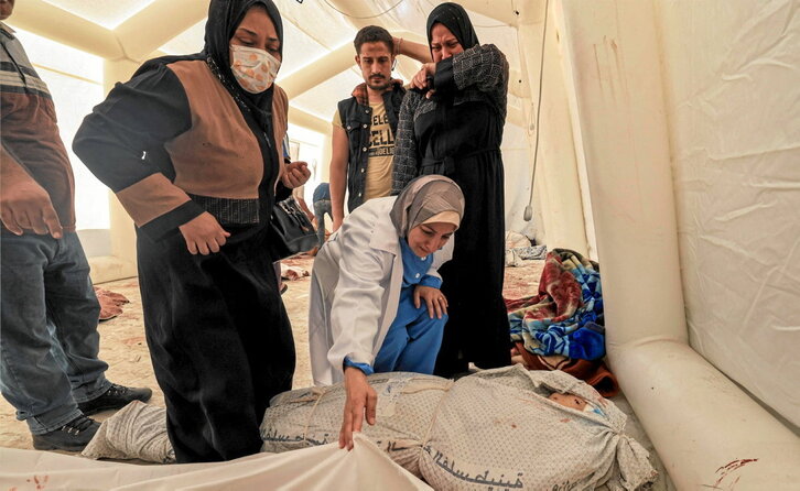 Mujeres palestinas identifican los cuerpos de algunos de los muertos en el ataque al hospital Al Ahli.