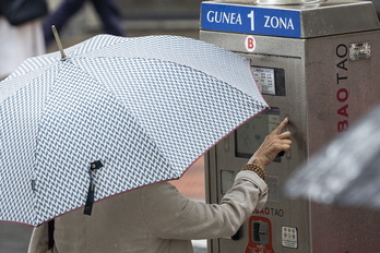 Una mujer ante una máquina de la OTA en una calle de Bilbo.