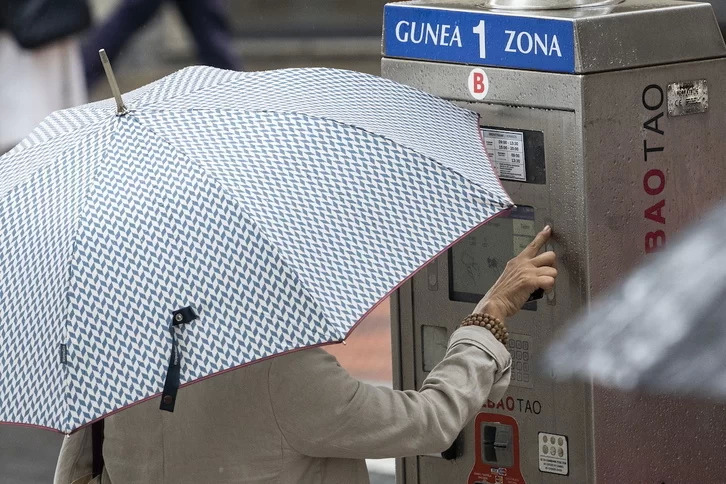 Una mujer ante una máquina de la OTA en una calle de Bilbo.