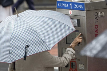 Una mujer ante una máquina de la OTA en una calle de Bilbo.
