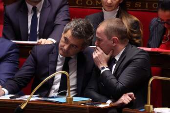 El ministro de Trabajo, Olivier Dussopt, habla al oído del titular de Interior, Gérald Darmanin, durante una sesión de control al Gobierno.