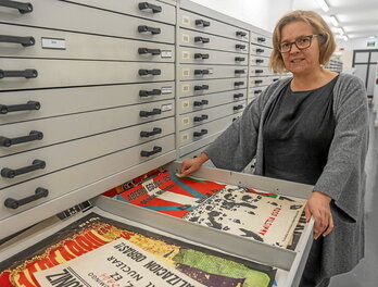 Miren Barandiaran, gordailu nagusian gordetako kartel batzuk erakusten.