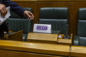Por orden de la presidenta del Parlamento de Gasteiz, un ujier retira los carteles de los escaños de EH Bildu.