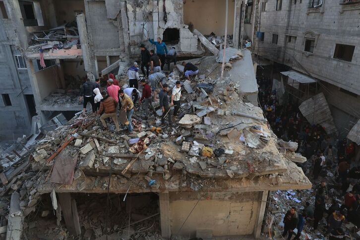 Palestinos buscan entre los escombros de un edificio bombardeado este viernes por Israel. 
