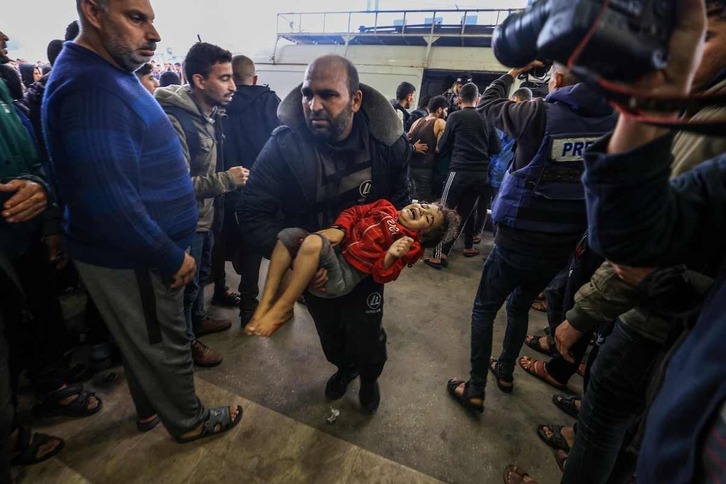 Un hombre lleva a una niña herida al hospital tras uno de los bombardeos en Jan Yunis.