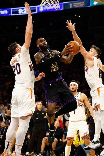 LeBron James logra encontrar el hueco entre dos defensores de los Phoenix Suns.