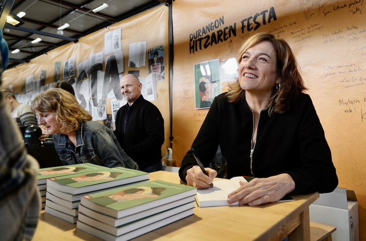 Karmele Jaio, irribarretsu, ‘Maitasun kapitala’ liburua zaleei sinatzen.