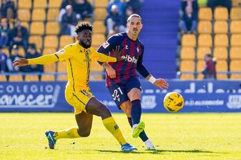 Ríos Reina y Eteki siguen con la mirada un envío del lateral sevillano.