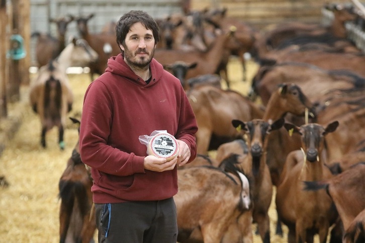 Gorka Muniozguren, bere ahuntzen esnearekin egindako gazta eskuetan duela.