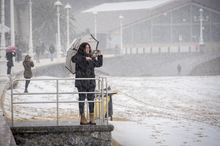 Una mujer fotografía la playa de Ondarreta nevada el pasado mes de febrero. 