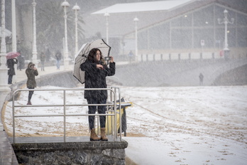 Una mujer fotografía la playa de Ondarreta nevada el pasado mes de febrero. 