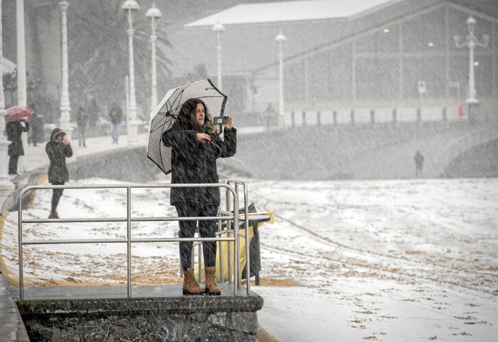 Una mujer fotografía la playa de Ondarreta nevada el pasado mes de febrero.