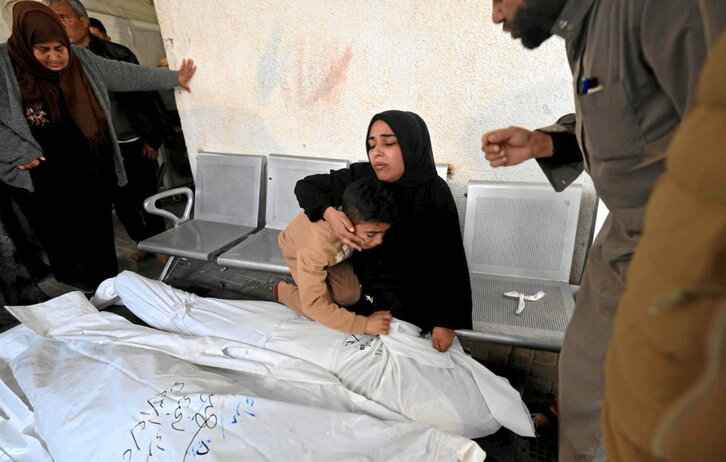 Familiares de Jehad Arafat, muerto en un bombardeo israelí, lloran junto a su cuerpo.