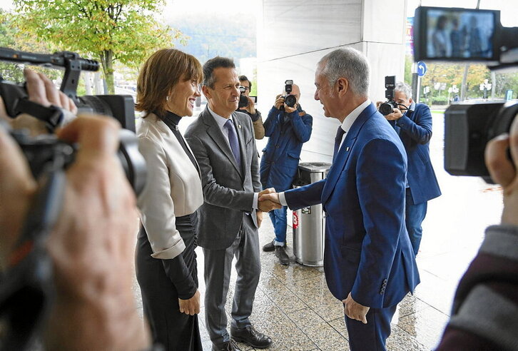 Iñigo Urkullu eta Jokin Bildarratz elkarri eskua ematen, EHUko errektore Eva Ferreira aurrean dutela.