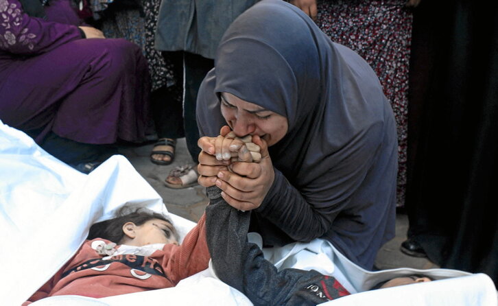 La madre de los gemelos de ocho años Ahmed y Jihan Nasser, muertos por las bombas israelíes, besa sus manos.