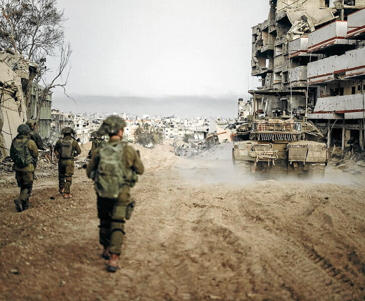 Tropas israelíes avanzan por una de las calles devastadas de Gaza.