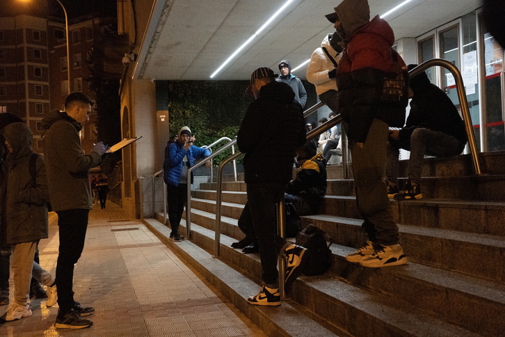 Un grupo de personas, a las puertas de un albergue en Iruñea.