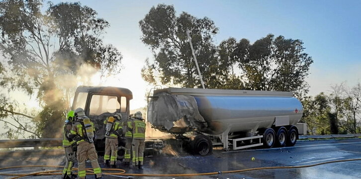 Bomberos apagando el incendio en el camión.
