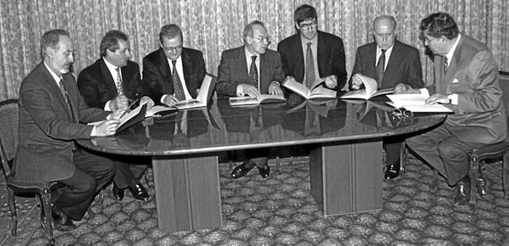 Ajuriaeneko Itunaren sinatze ekitaldia; argazkiaren erdian,  ezkerretik laugarrena, Jose Antonio Ardanza (EAJ) eta bere alboan, Txiki Benegas (PSE).