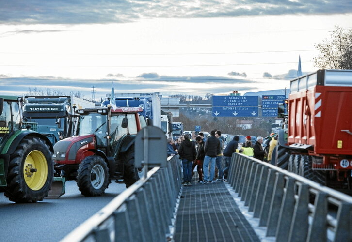 Agricultores en el punto de bloqueo situado en la circunvalación de Baiona por la A63.