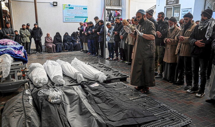 Palestinos rezan junto a los cadáveres de familiares muertos en un bombardeo israelí sobre Rafah.