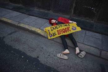 Un manifestante con una nariz de payaso sostiene una pancarta en la que se lee ‘Doctrina del Shock’ durante una protesta frente al Congreso mientras los legisladores debaten el proyecto de ley.