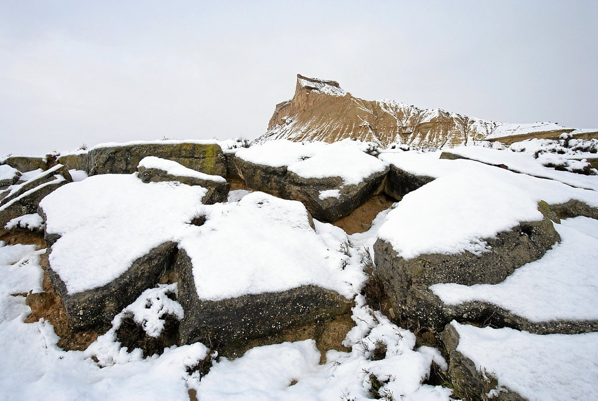 Bloques de rocas areniscas cuarteados junto al cabezo de Sanchicorrota, al fondo.