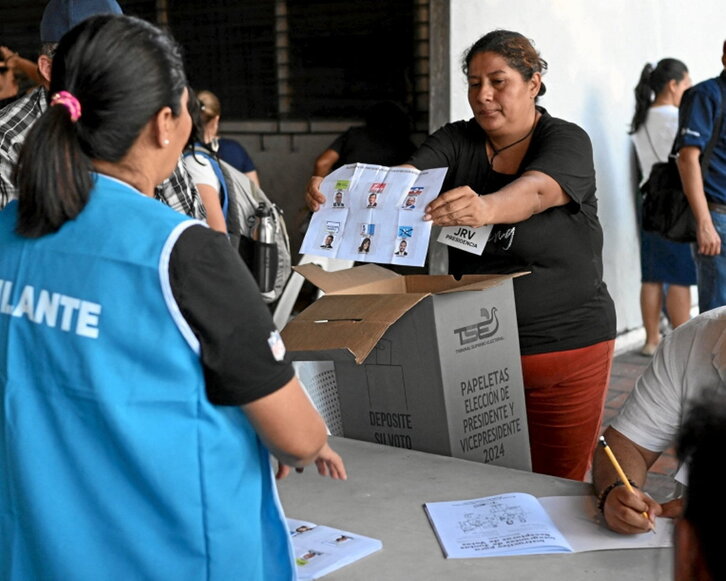 Una mujer muestra una papeleta en el recuento.
