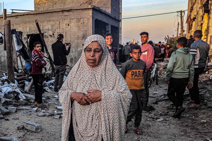 Mujer palestina camina entre los escombros de edificios destruidos en Rafah.