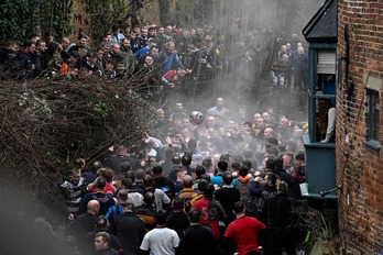 Integrantes de los dos equipos pugnan por el balón en una calle de Ashbourne.