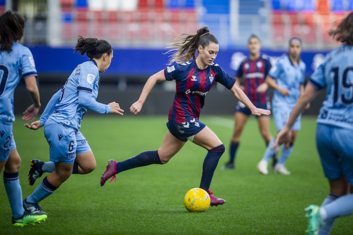 Andrea Sierra avanza con el balón perseguida por Paula Fernández.