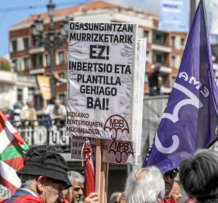 Un cartel pidiendo más personal en Osakidetza en una manifestación.