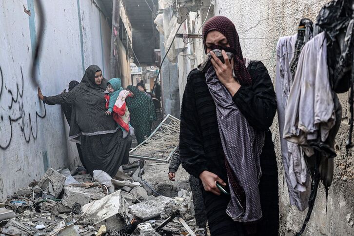 Una mujer se cubre por el olor entre escombros en una callejuela de Rafah tras un bombardeo israelí.