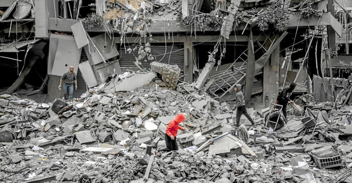 Palestinos buscan algo que recuperar entre las ruinas dejadas por las bombas israelíes en la ciudad de Gaza.