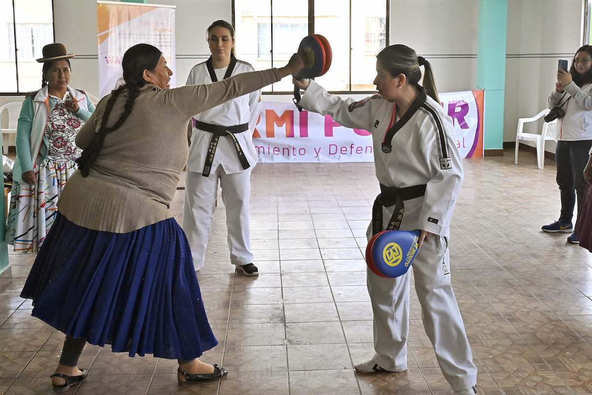 Una mujer aymara practica taewkondo con Laura Roca y Kimberly Nosa (Aizar RALDES / AFP)