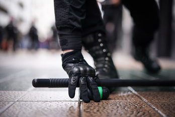 Un ertzaina recoge un proyectil de foam tras la carga del domingo en Gasteiz.