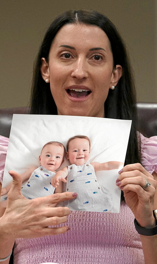 Julie Cohenek, «in vitro» ernalkuntzako pazienteak, bere seme-alaben argazki bat erakusten du paziente eta osasun profesionalekin otsailaren 27an Birminghamen egindako mahai inguru batean.