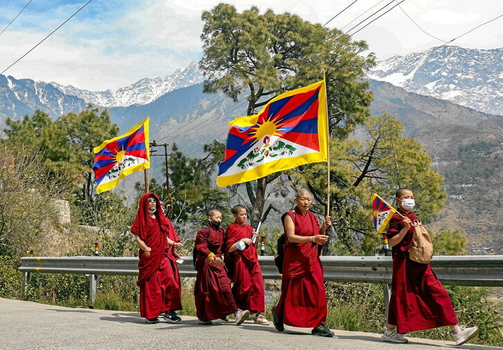 Monjes tibetanos exiliados en India ostienen banderas del Tíbet durante una marcha por la paz en con motivo del 65 aniversario del Alzamiento Tibetano contra la ocupación china, el pasado domingo. Sanjay BAID | AFP