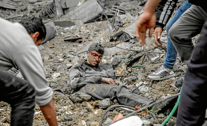 Palestinos socorren a un herido en uno de los bombardeos en la ciudad de Gaza.