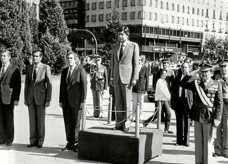 Ezkerrean, Felipe Gonzalez Espainiako Poliziaren ekitaldi baten buru Madrilen. Ondoan, herritarrak eta bolondresak lokatza eta uholdeek eramandako objektuak garbitzen, Andoainen