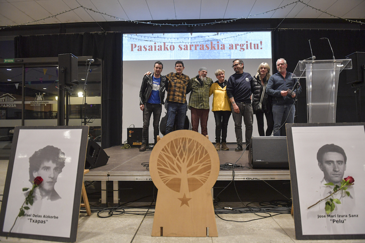 Lau hildakoek argazkiak eta senideak atzean, Azpeitiako ekitaldian, Drogasekin batera.