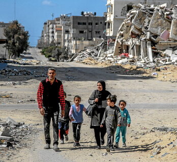 Una familia palestina camina entre los edificios destruidos de la ciudad de Gaza.
